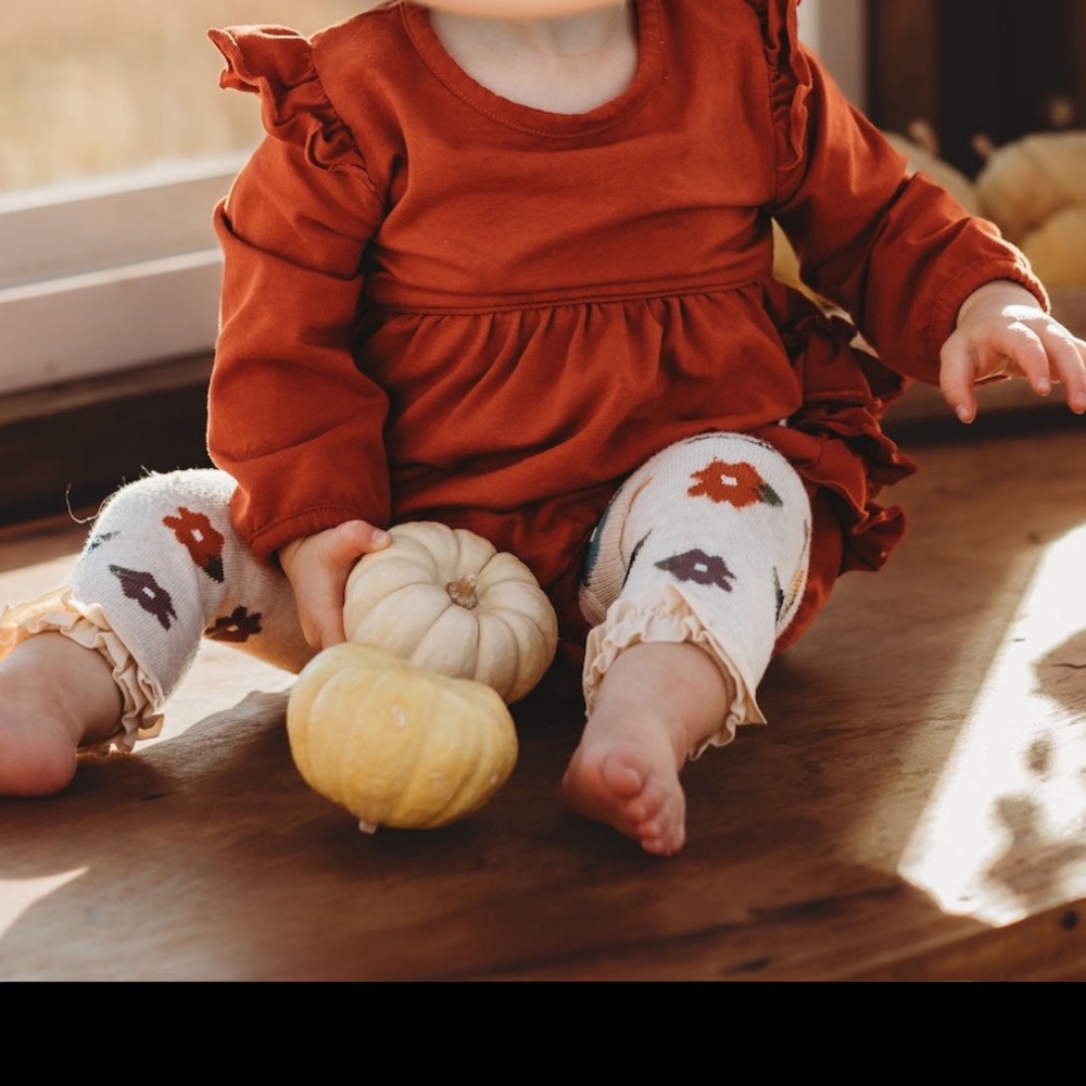 RuffleButts girl rust orange bubble romper and autumn floral footless tights